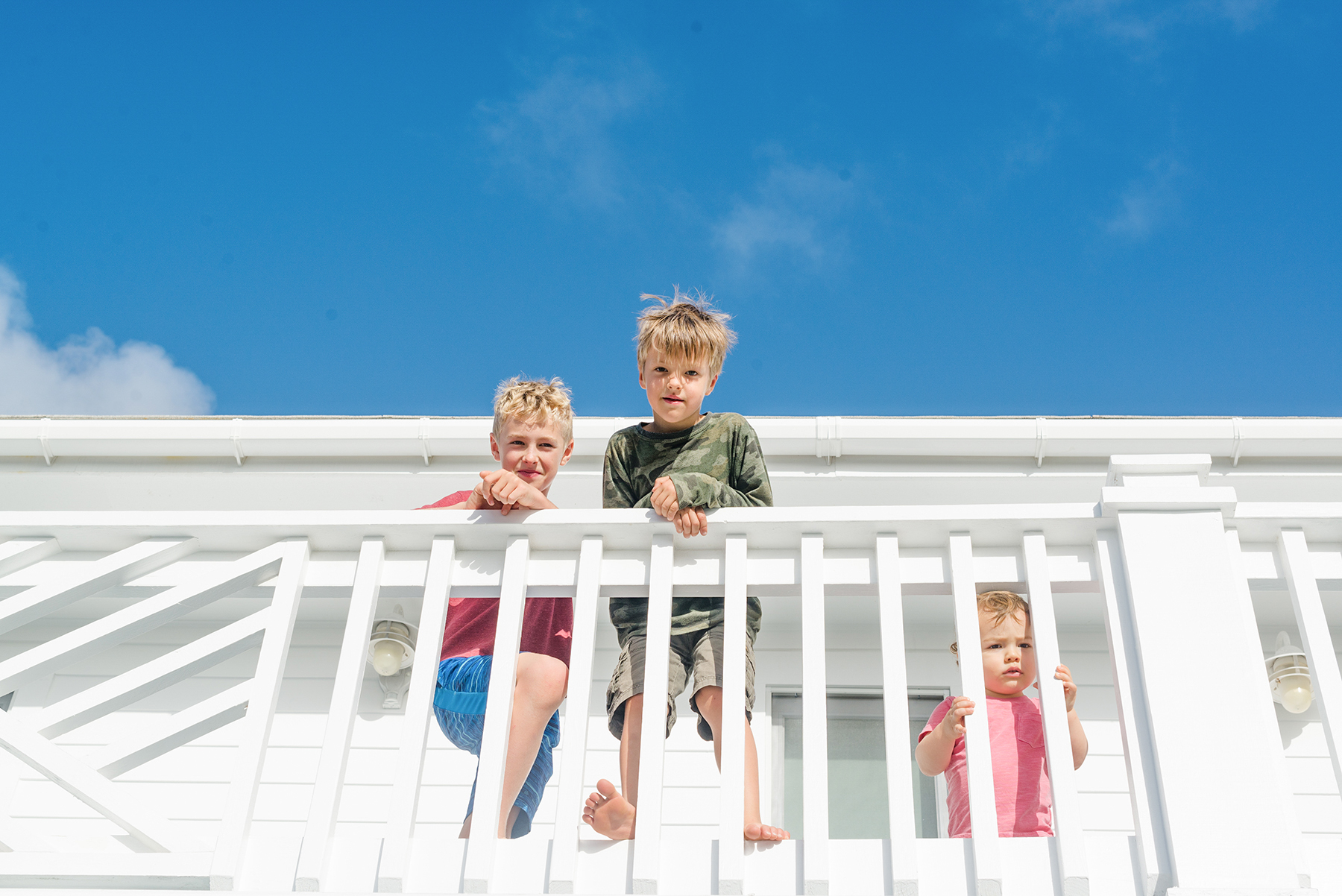 cousins-look-over-balcony-family-vacation