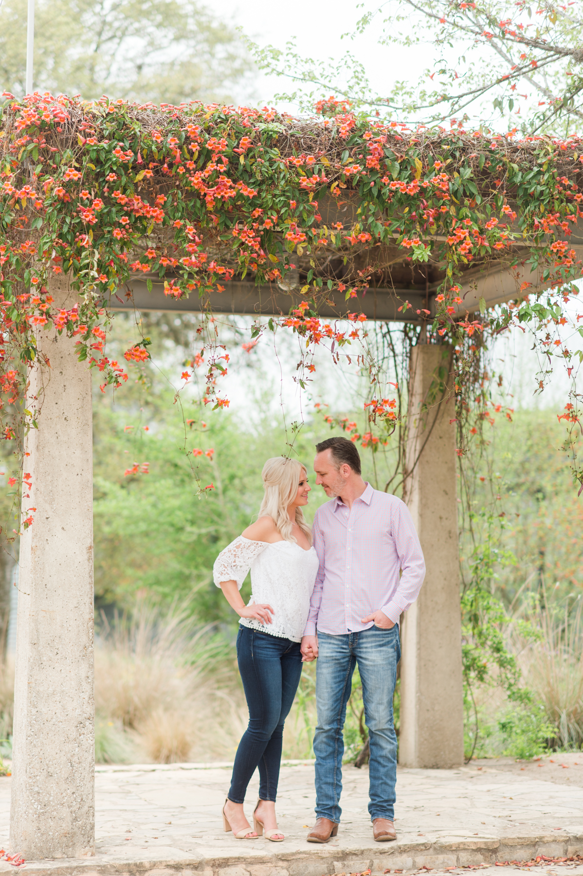 The couple poses under the trellis.