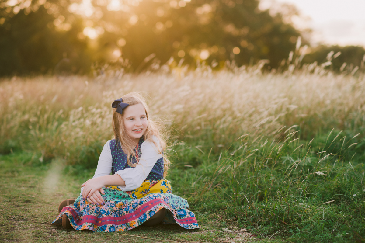 little-girl-smiles-camera-sunset-portraits-brushy-creek-lake-park