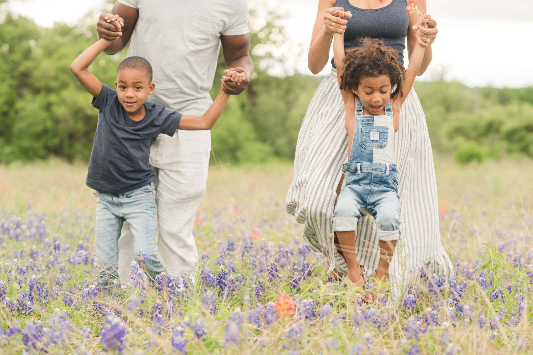 kids-playing-with-parents-dripping-springs-field-wildflowers-austin-family-photography