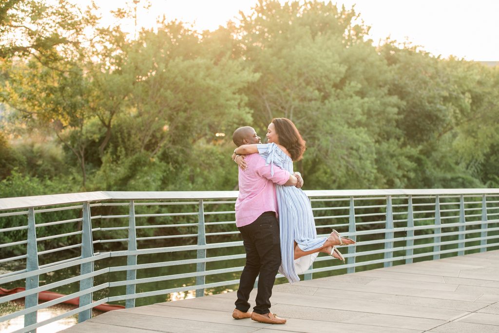 engaged-couple-dances-boardwalk-lake-austin