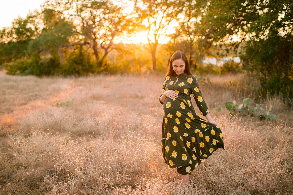 pregnant-woman-dances-field-sunset-dress-austin