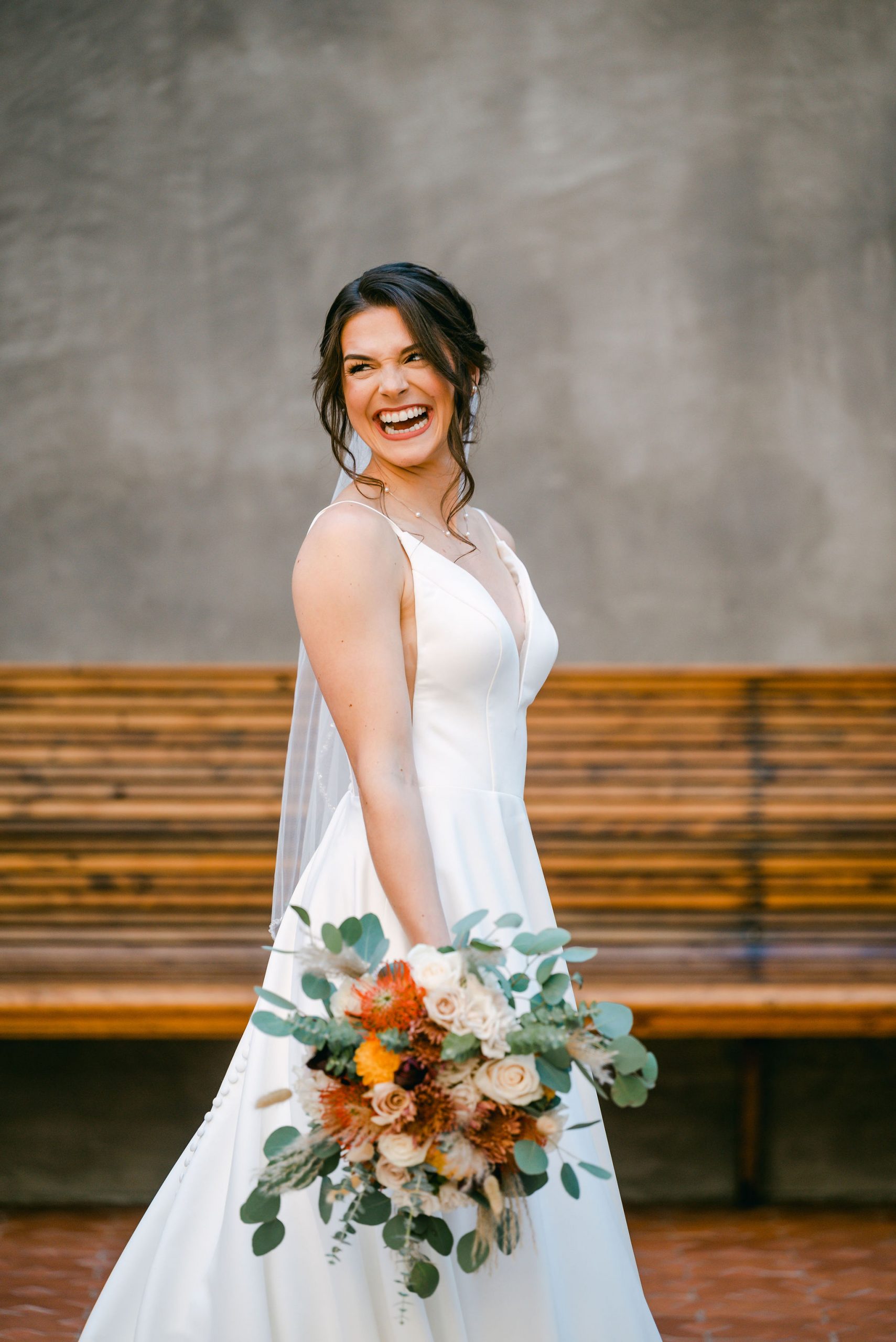 bride-laughs-against-rustic-stone-wall-hotel-emma