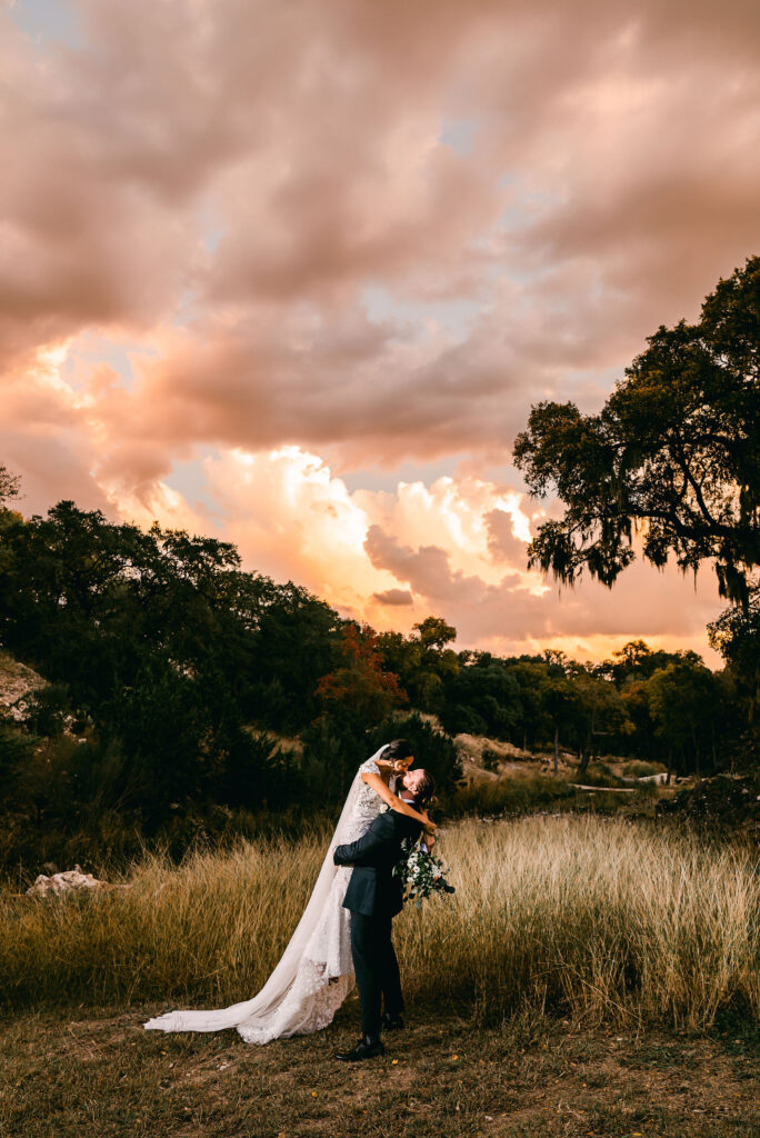 groom-picks-up-bride-under-texas-sunset