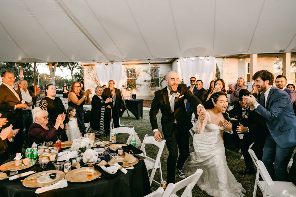 Couple-enters-reception-laughing-Austin-wedding-photographer