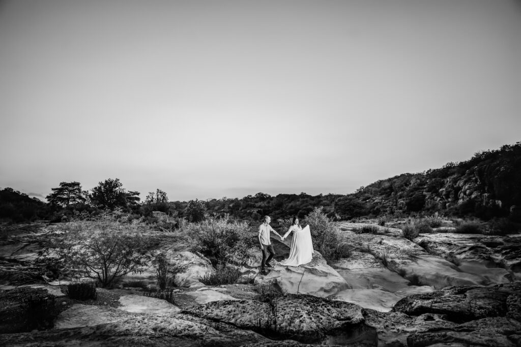 Wide-landscape-couple-walking-through-pedernales-state-park-maternity-photography-austin