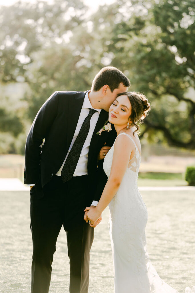 couple kiss and hold hands during sunset photos
