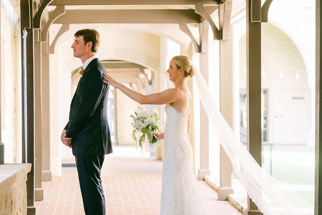 bride taps groom on shoulder during first look
