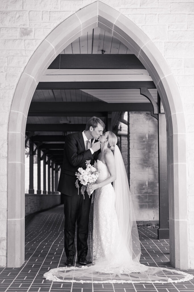 Austin-couple-kisses-under-church-arch-after-ceremony