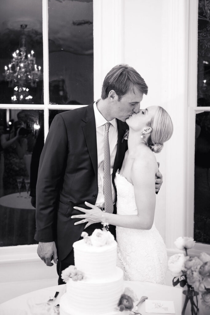 couple kiss before cutting the cake