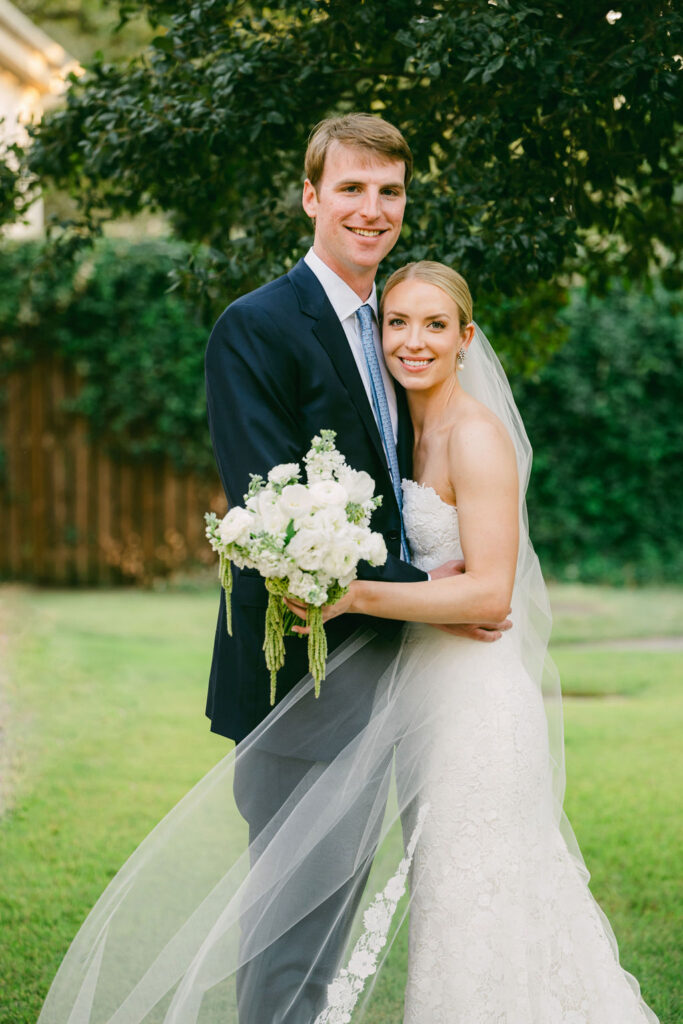 couple embrace with the green grass behind them for wedding portraits