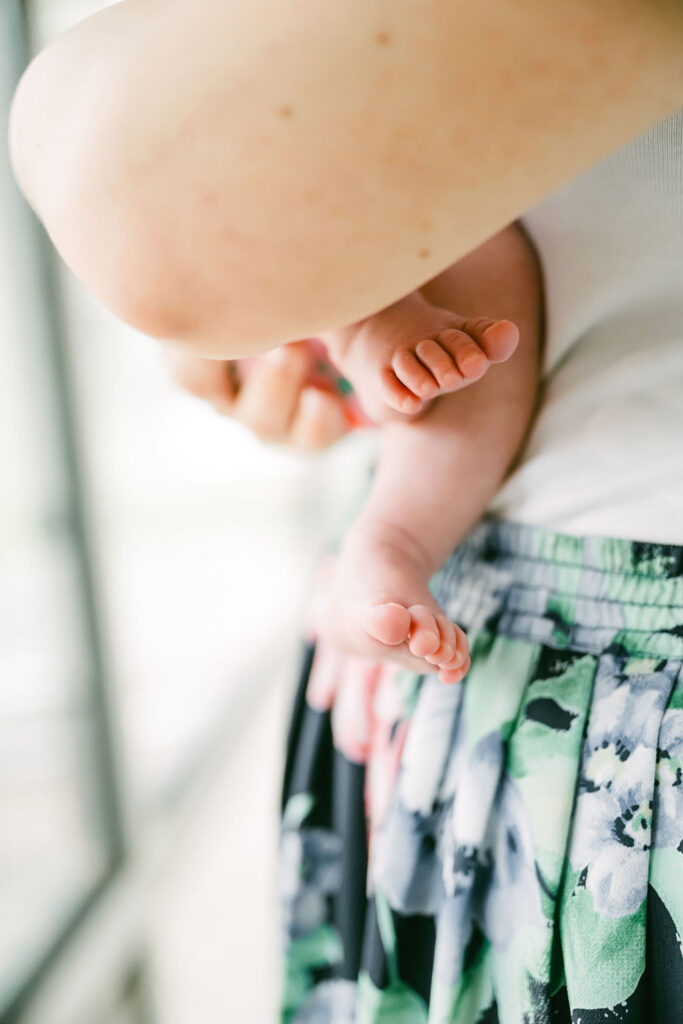 Top Austin newborn photographers capturing baby hands and feet in a relaxed home setting