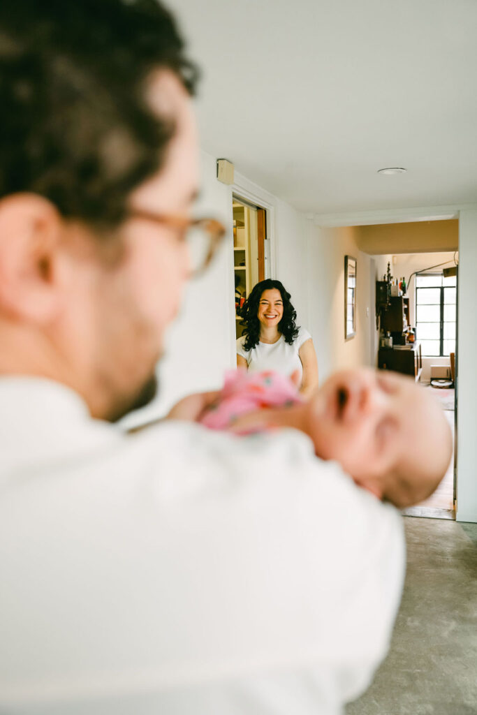 Atx photographer captures mom watching dad hold newborn in sweet moment
