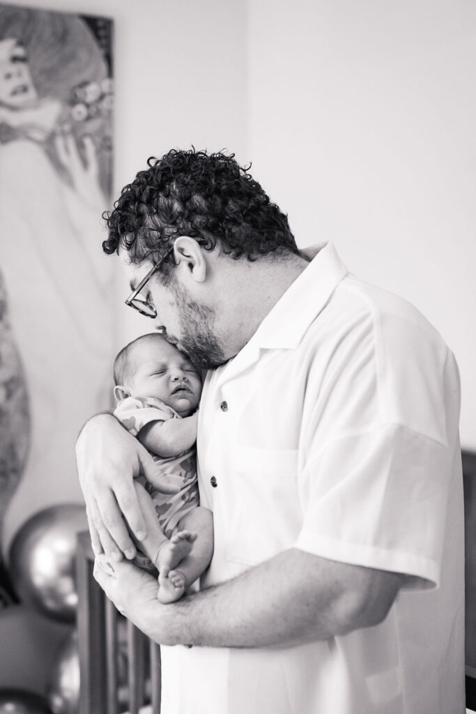 emotional photo in Austin of dad kissing baby on forehead