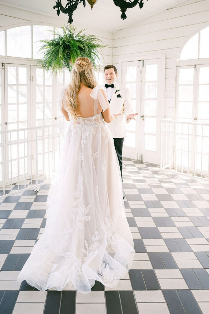 Bride and groom have first look at Woodbine Mansion in Austin with checkered floor and windows