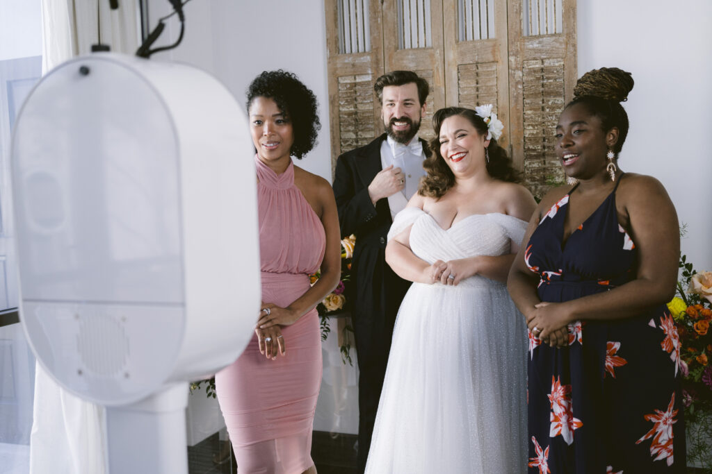 couple and guests take photos with a photo booth rental