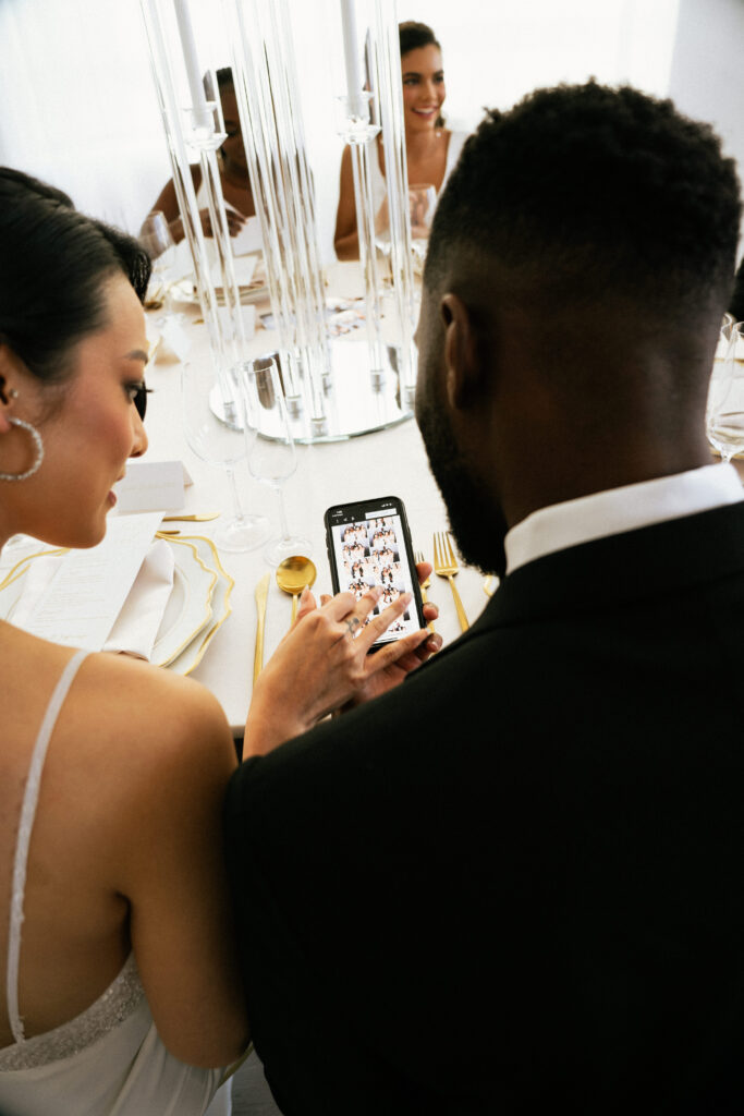 couple looking at the photo booth photos on their phones