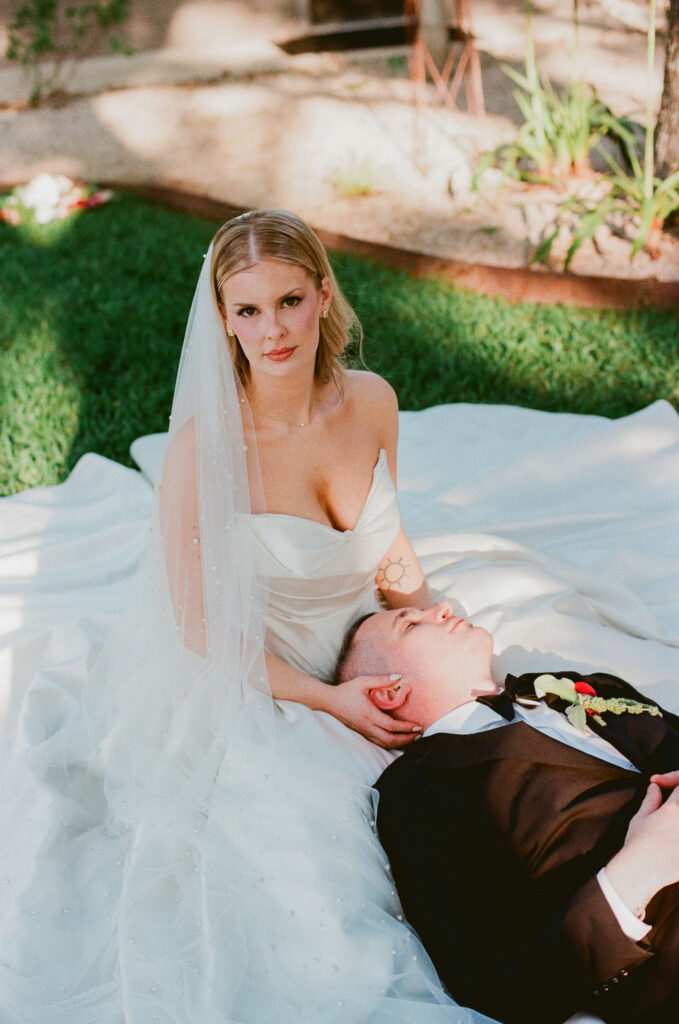 groom laying on top of bride and her dress